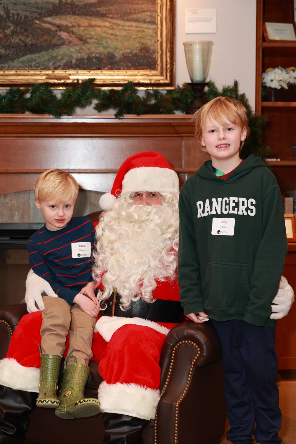 Two brothers sitting with Santa together.